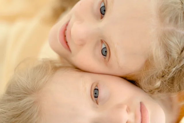 Delightful portrait of twin girls with blond hair, close-up view highlighting their joyful expressions and togetherness. Athlete lookalikes: how sport, kit and the sideline lens shape seven famous pairs
